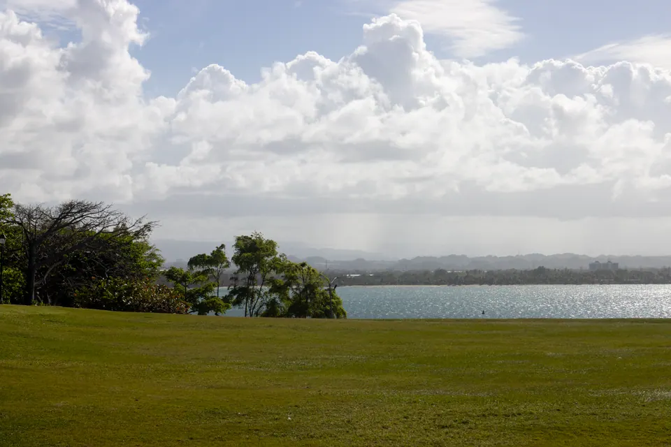 A green lawn above a bay in San Juan, Puerto Rico, under tall clouds